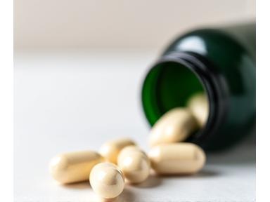 Image of probiotic capsules spilling gently from a bottle onto a clean surface.